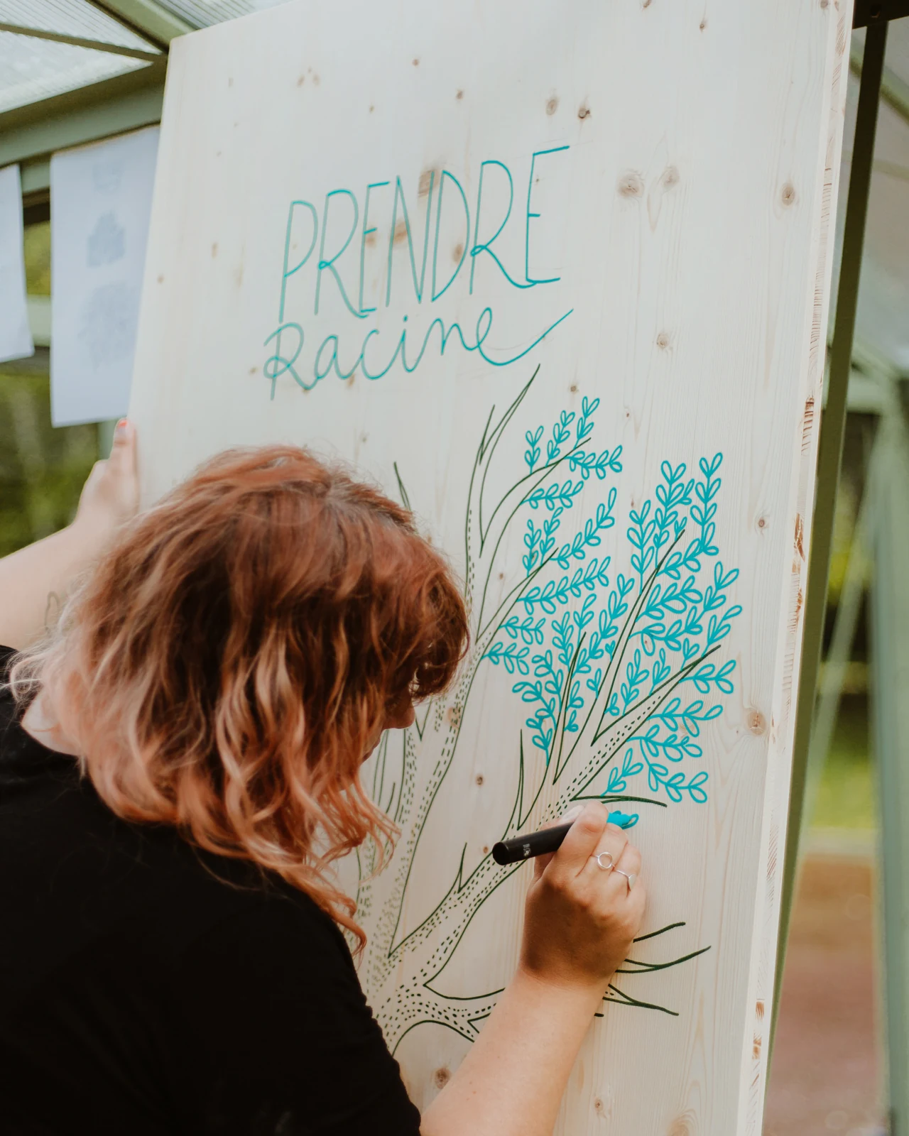 Une personne dessine au feutre sur un panneau
